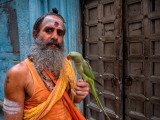 Muž s papouškem ve Váránasí (Indie, Dreamstime)
